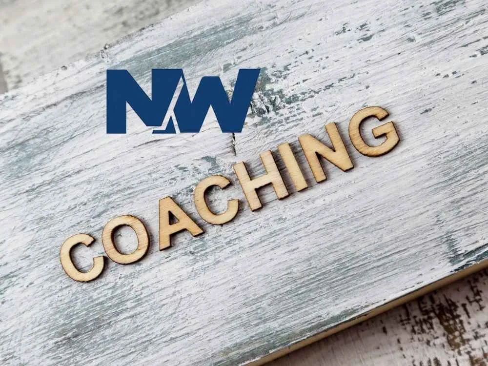 Holzbuchstaben auf einem Holzbrett bilden das Wort Coaching
